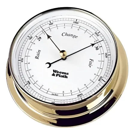 The Weems & Plath Brass Endurance 125 Barometer, crafted to embody nautical tradition with a weatherproof design, features a white face displaying the brand "Weems & Plath." Its needle indicates pressure readings labeled "Rain," "Change," and "Fair," spanning from 28 to 31 inches of mercury.