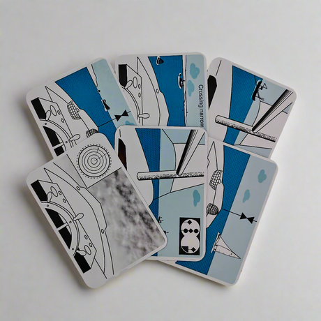 A fan layout of six illustrated Flip Cards from the "Rule of the Road" collection by Flip Cards, showcasing various abstract designs predominantly in blue, white, and gray. The designs feature geometric shapes, sailing boats, and nautical themes inspired by mariner navigation. The cards are spread out on a white surface.