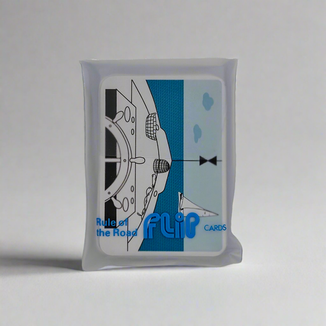 A packet of "Flip Cards - Rule of the Road," branded by Flip Cards, showcases an illustration of a ship's bow along with essential navigational symbols for mariners on the front. The packet is silver with shades of blue and black, appears unopened, and is set against a plain background.