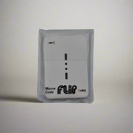 A card, protected by a translucent sleeve, showcases the Flip Cards - Morse Code logo and a Morse symbol featuring a dash, dot, and dash. An arrow at the top left guides users on the flipping direction, making it ideal for mariners learning Morse code.