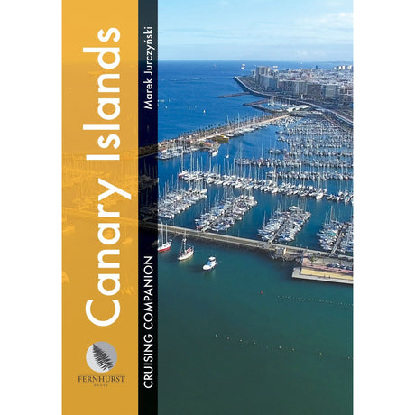 The "Canary Islands Cruising Companion" by Fernhurst Books features an aerial view of a marina with docked boats, cityscape, and ocean. The title, displaying essential nautical information, runs vertically along the left side.