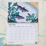 A May 2026 page from the Hannah Wisdom Coastal Calendar 2026 by Hannah Wisdom Textiles, featuring "Mackerel at Whistand Bay"—an illustrated fish and seaweed scene above a nautical map.