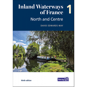 The cover of "Inland Waterways of France | Volume 1 | North and Centre" by David Edwards-May, ninth edition, showcases a tranquil river landscape surrounded by lush greenery, featuring a boat docked near the bank under a pristine blue sky. Highlighting waterways such as the Seine-Nord Europe Canal, the Imray logo is prominently displayed in the bottom right corner.