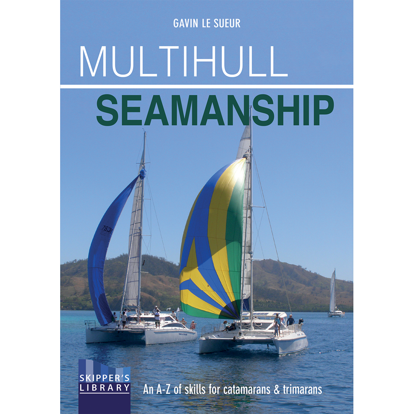 The cover of "Multihull Seamanship" by Fernhurst Books shows a trimaran and catamaran with colorful sails under sunny skies, surrounded by calm blue waters and hilly terrain, with The Skipper's Library logo at the bottom.