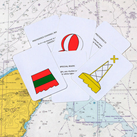 The Flip Cards: Sailor Essentials Set by Flip Cards features a collection of cards depicting nautical symbols, such as a striped buoy, a vertically striped red and white buoy, and a yellow and white lighthouse. The cards are arranged over a detailed nautical map, incorporating essential IALA buoyage concepts for effective sea navigation.