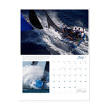 A page from the Ultimate Sailing 2025 Calendar by Sharon Green for July showcases breathtaking images, with the top photo depicting a crew navigating through exhilarating sailing events and the bottom image capturing a boat slicing through waves. The calendar dates are neatly arranged on the right side.