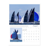 The August page of the Ultimate Sailing 2025 Calendar showcases an exhilarating image of sailboats with black and blue sails competing on open water. A smaller inset highlights boats with vibrant multi-colored sails. Each calendar day comes alive with the excitement of sailing events, thanks to renowned photographer Sharon Green from the Sharon Green brand.