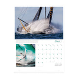 A page from the Ultimate Sailing 2025 Calendar for June features two stunning images. The larger image captures a sailboat slicing through ocean waves with water splashing dramatically, while the smaller branded image focuses on a boat sailing swiftly. Curated by Sharon Green, this calendar is a celebration of thrilling sailing events.