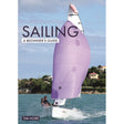 The cover of "Sailing: A Beginner's Guide" by Fernhurst Books shows two beginners mastering sailing techniques on a small boat with a large purple sail, gliding across water. Trees and buildings are in the background under a blue sky.