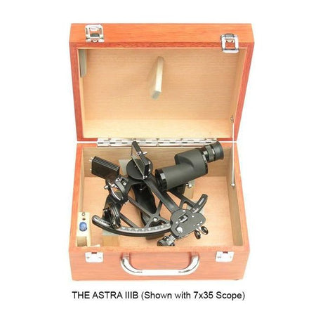 A Celestaire Astra IIIB Deluxe Sextant from SailorShop, equipped with a 7x35 scope, is displayed in an open wooden case, highlighting its precision for celestial navigation. The case is designed with robust metal clasps and a convenient handle. Below it is the text: "THE ASTRA IIIB (Shown with 7x35 Scope).