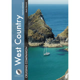 A sailboat floats in clear turquoise water near rocky cliffs. The cover features "West Country Cruising Companion" by Fernhurst Books—an essential guide for sailing adventures.