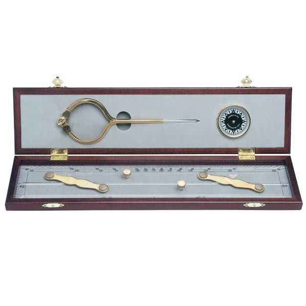 The Weems & Plath Elegant Navigation Set is showcased in a fine wooden box. This set comprises a brass compass, a divider, and a parallel ruler. The interior of the box is lined with light-colored material, and the tools are meticulously arranged in designated slots.